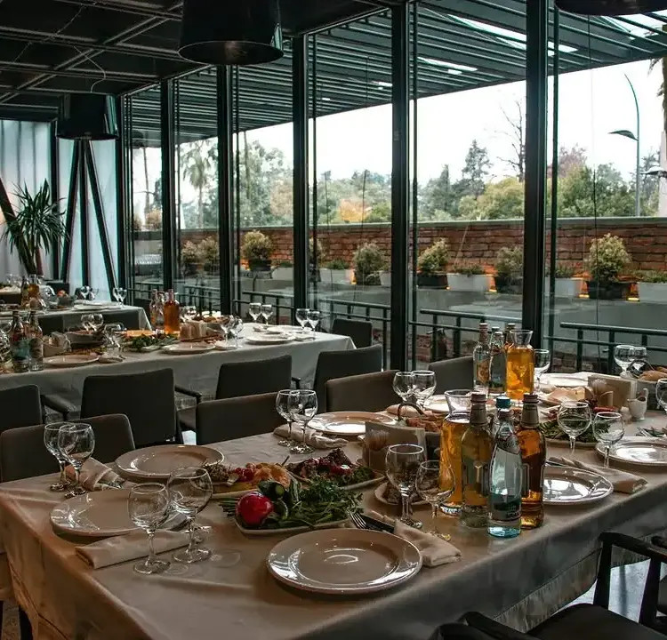 Set dining tables beside Bern’s glass-fronted terrace